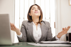 Beautiful Hispanic business woman relaxing and doing some meditation at her office